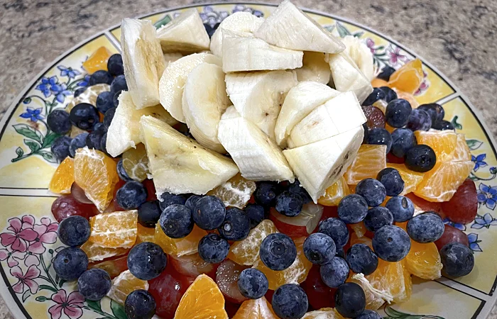 Large fruit salad with blueberries and bananas on top